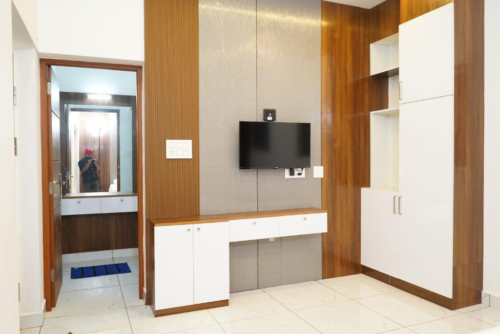 a bathroom with a tv on a wall at Mountain Mist Ranipuram in Kallar