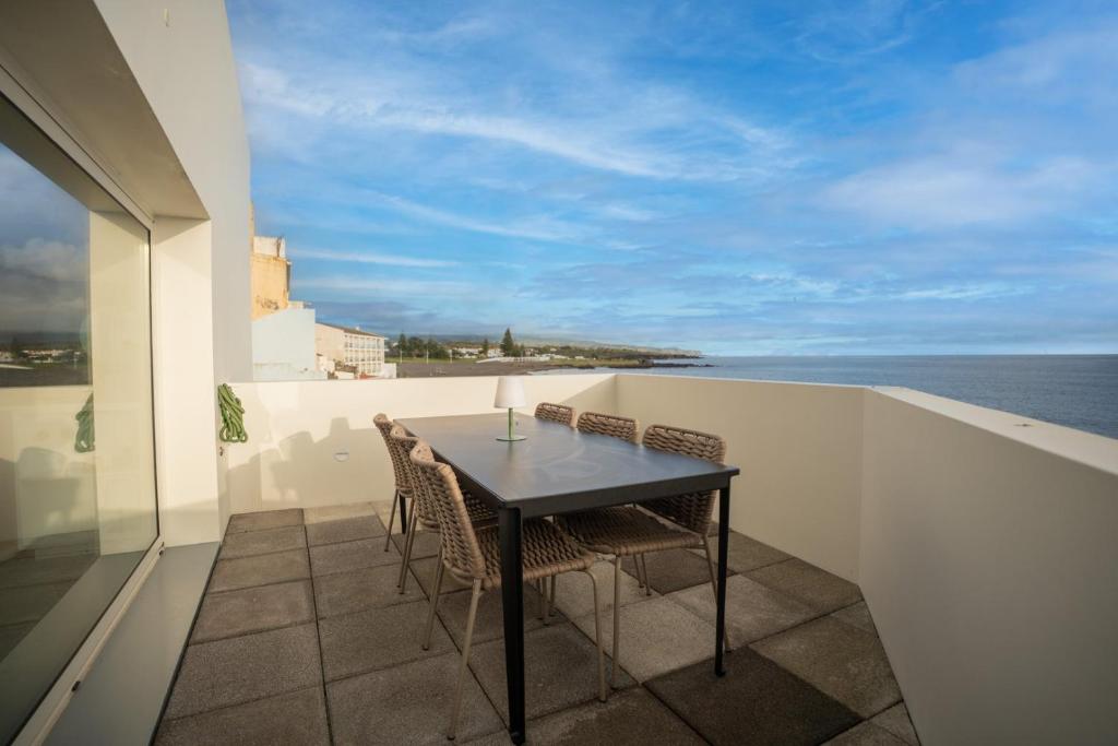 a table and chairs on a balcony with the ocean at The Lookout | Private Beach Access in São Roque