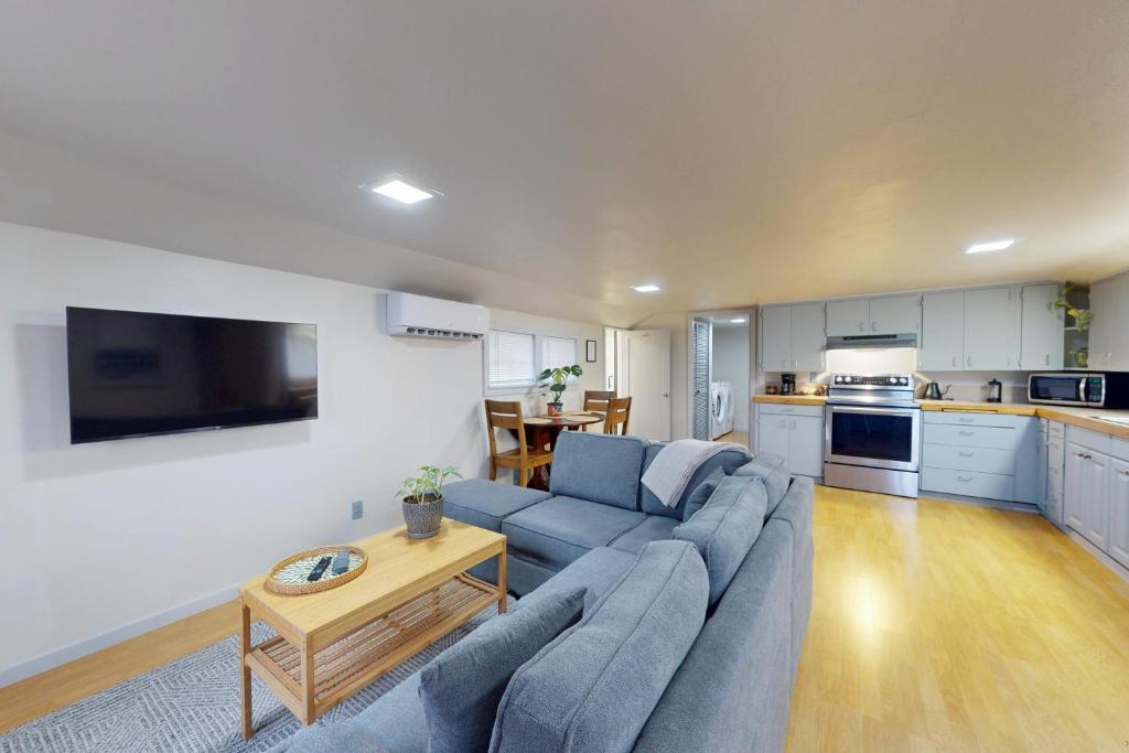 a living room with a blue couch and a kitchen at Shore Pine Cottage in Grayland