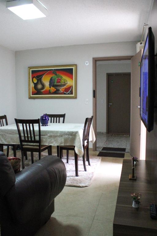 a dining room with a table and chairs and a television at Diamante em Brasília in Brasília