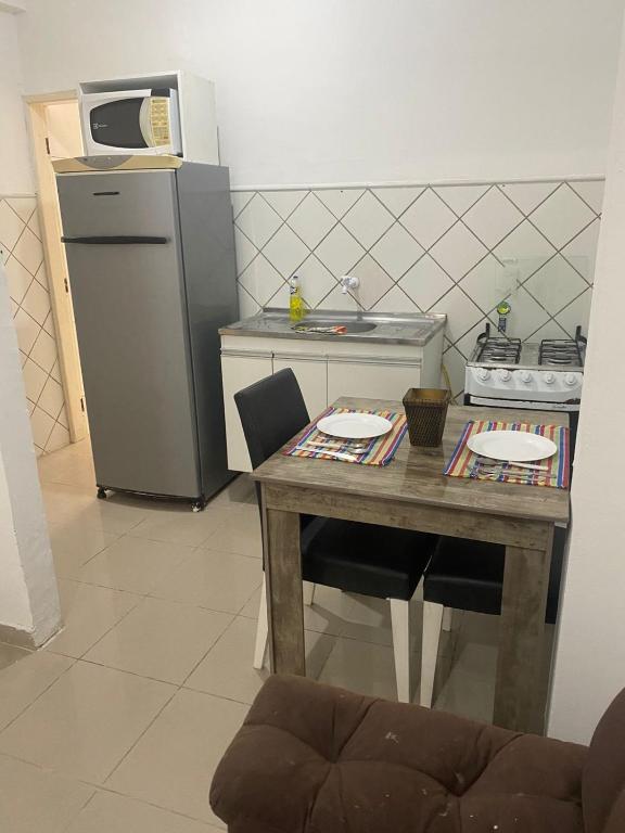 a small kitchen with a table and a refrigerator at Comendador flats350 in Maceió