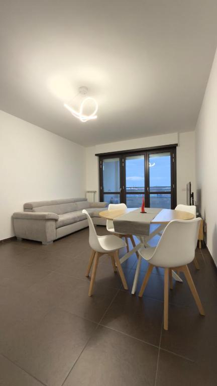 a living room with a table and chairs and a couch at Urban Nest Living in Sesto San Giovanni