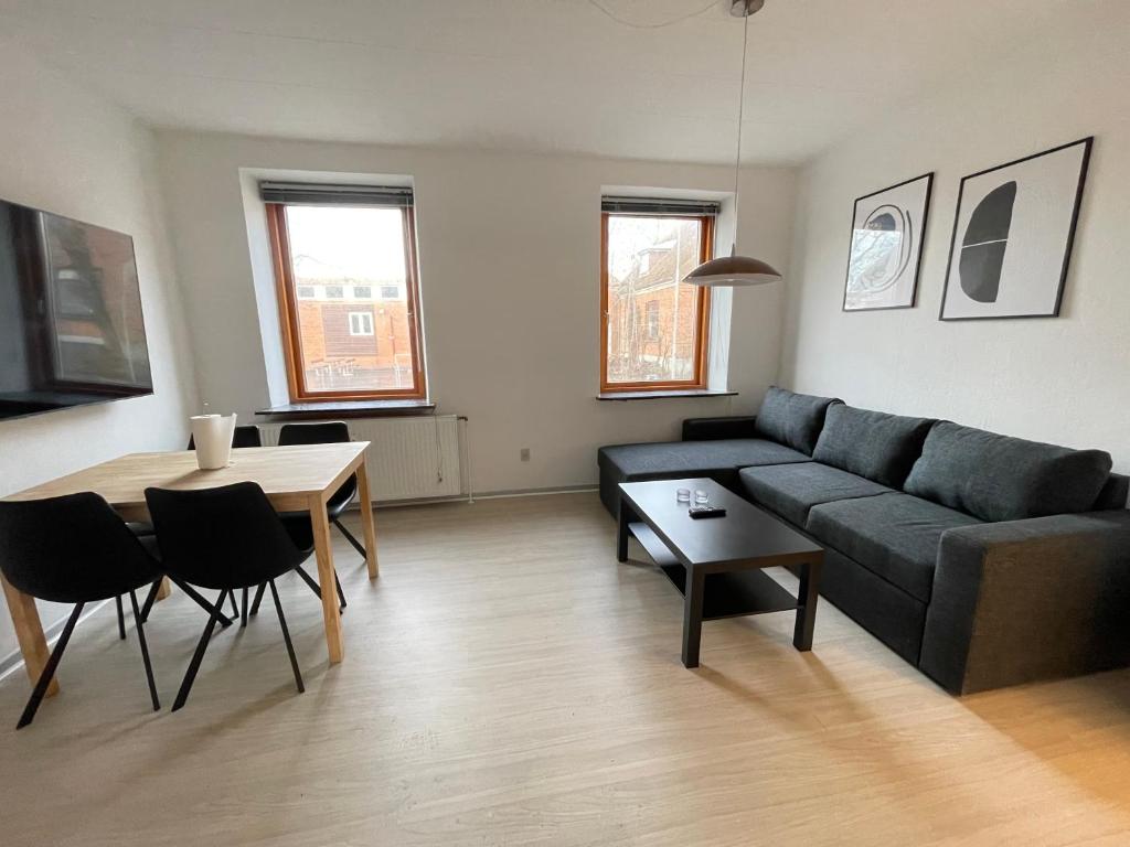 a living room with a couch and a table at Modernized Bed & Bath in Holstebro