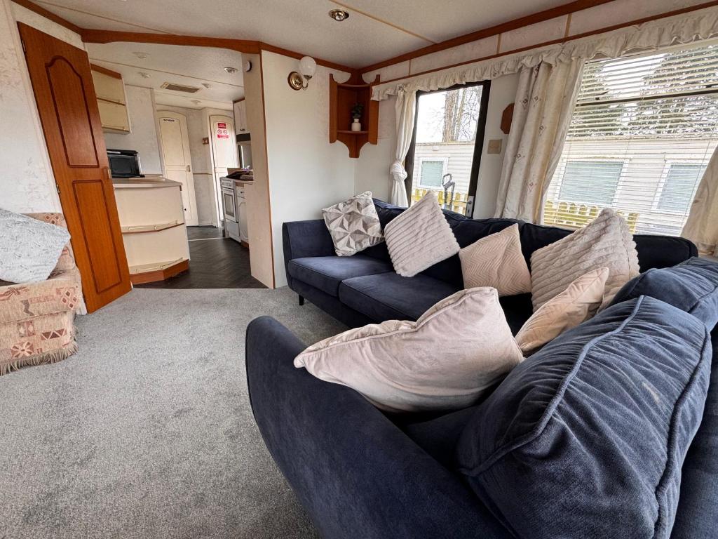 a living room with a blue couch with pillows at No 26 Mountain View in Cockermouth