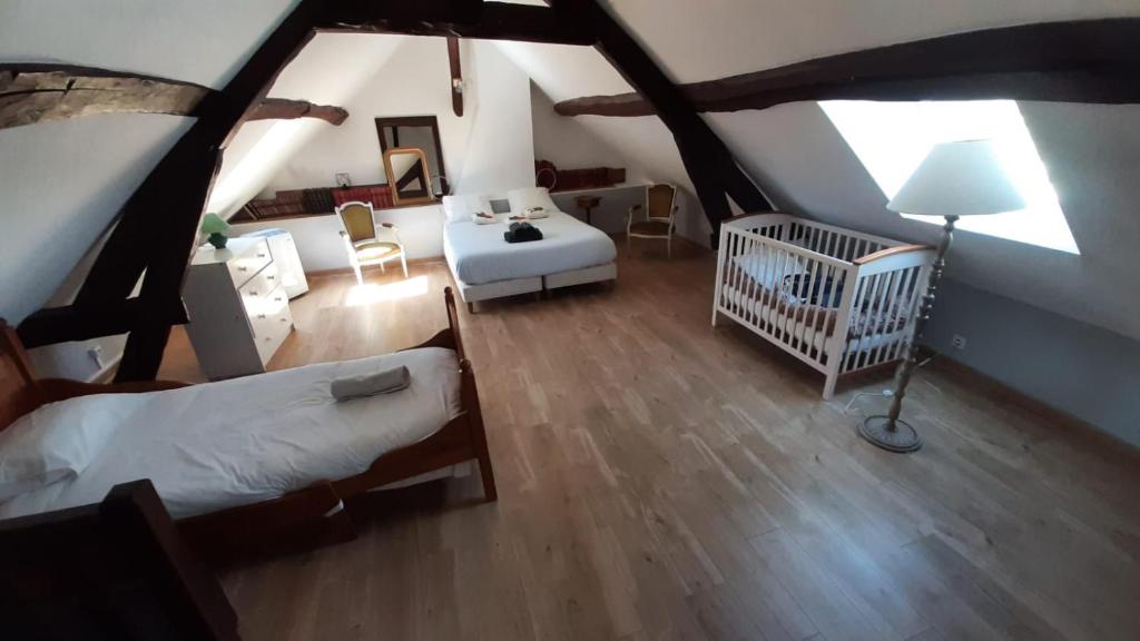 a large room with two beds and a crib at Maison avec cour et jardin in Marolles-sur-Seine