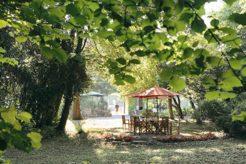 Cit'Hotel Avallon Vauban في أفالون: طاولة نزهة وشرفة في الحديقة