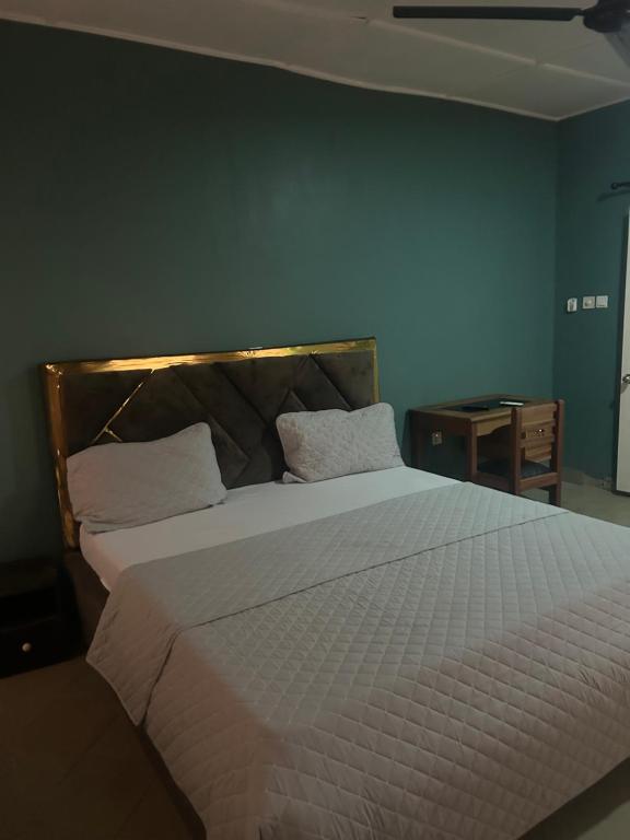 a bedroom with a large white bed with two pillows at Macdel Guesthouse And Condos in Kumasi