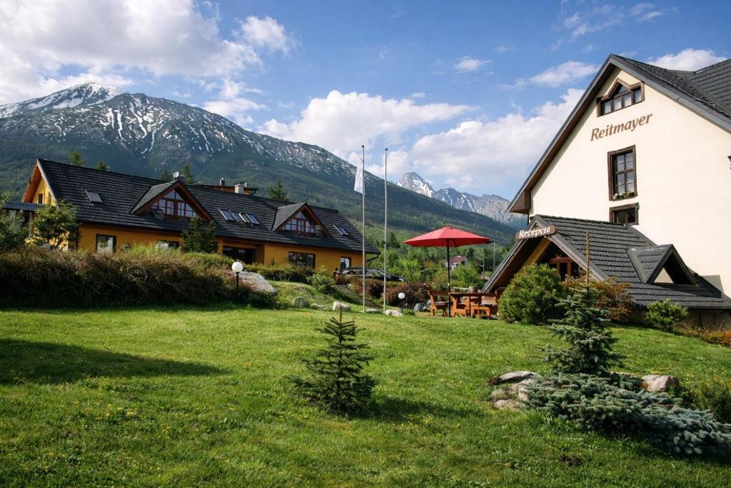 a house in a field with mountains in the background at Reitmayer in Starý Smokovec