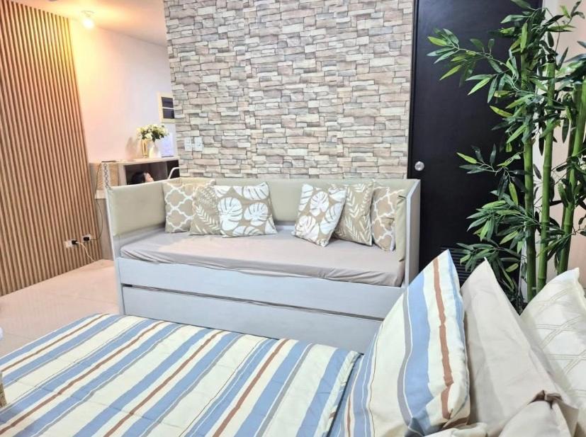 a couch in a living room with pillows on it at STUDIO TYPE CEBU CITy in Cebu City
