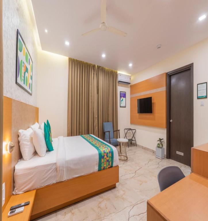 a hotel room with a bed and a desk at The Kalvin Plaza in New Delhi