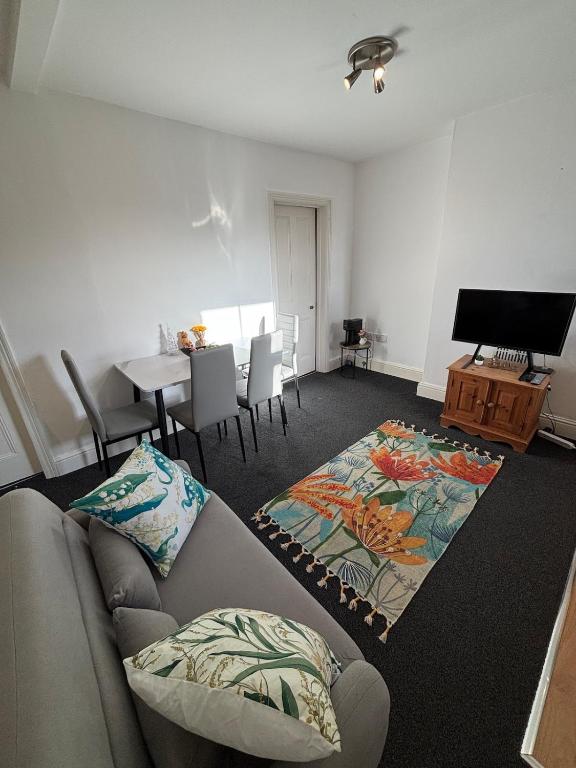a living room with a couch and a table at Leamington Spa Boutique Two Bedroom Flat in Leamington Spa