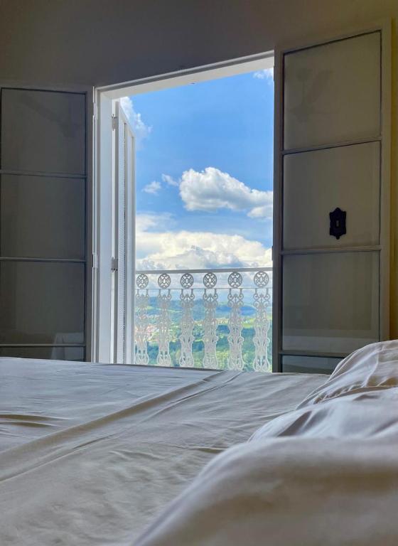 a bedroom with a bed and a large window at Pousada Lourenço in Nazaré Paulista