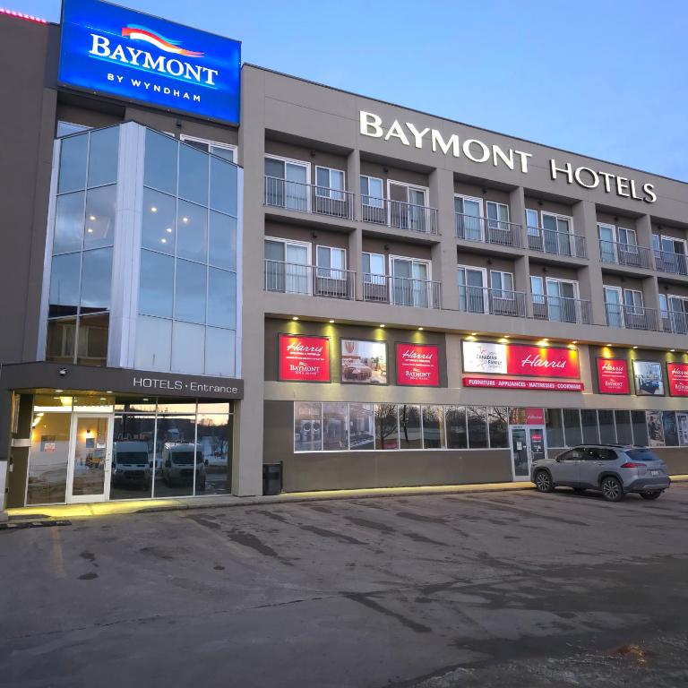 a building with a car parked in front of it at Baymont by Wyndham Fort McMurray in Fort McMurray