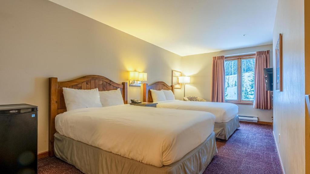a hotel room with two beds and a window at Cahilty #225 home in Sun Peaks