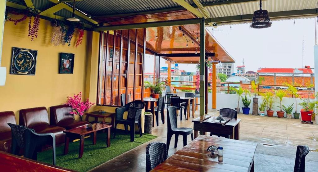 a restaurant with tables and chairs on a patio at Heliconia's Inn in Puerto Maldonado