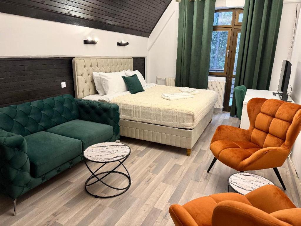 a bedroom with a bed and a couch and chairs at Goldel Resort in Delčevo