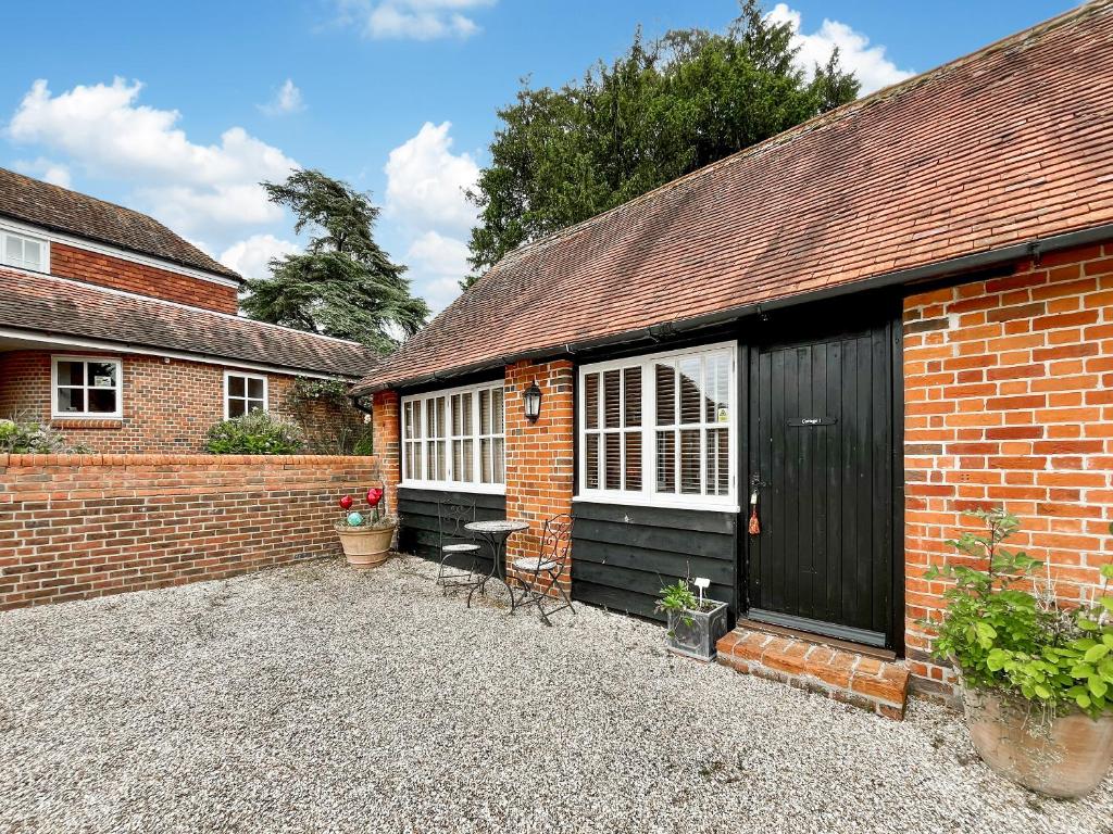 a brick house with a black door and two windows at Cottage 1 - Uk46611 in Broughton