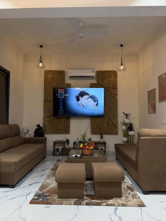 a living room with a couch and a tv on a wall at Nesara the nature villa in Jāmb