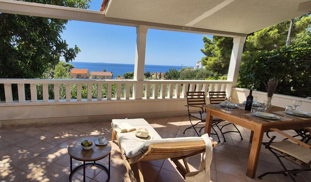 a patio with a table and chairs and a view of the ocean at Apartmani Dolac in Ivan Dolac