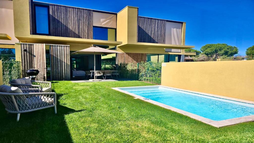 a house with a swimming pool in the yard at Villa Rimah, Sunny Algarve, Entire Villa "heated" pool, Golf, walk to Beaches & Long Stays by Clever Details in Vilamoura