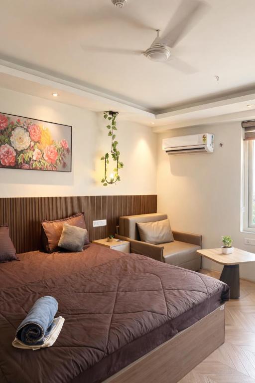 a bedroom with a large bed and a chair at Luna Stays in Greater Noida