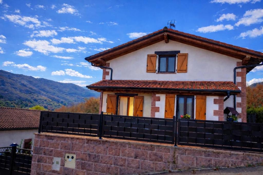 a white house with a black fence at El eco de los robles in Sumbilla