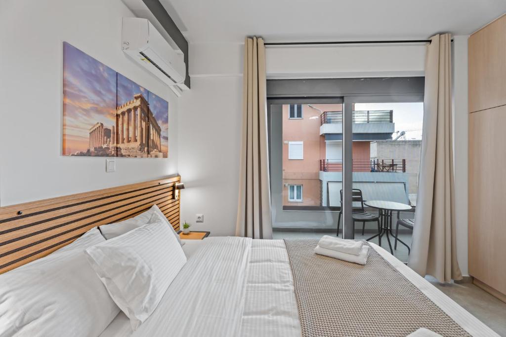 a bedroom with a large bed and a balcony at Athens Vein in Athens