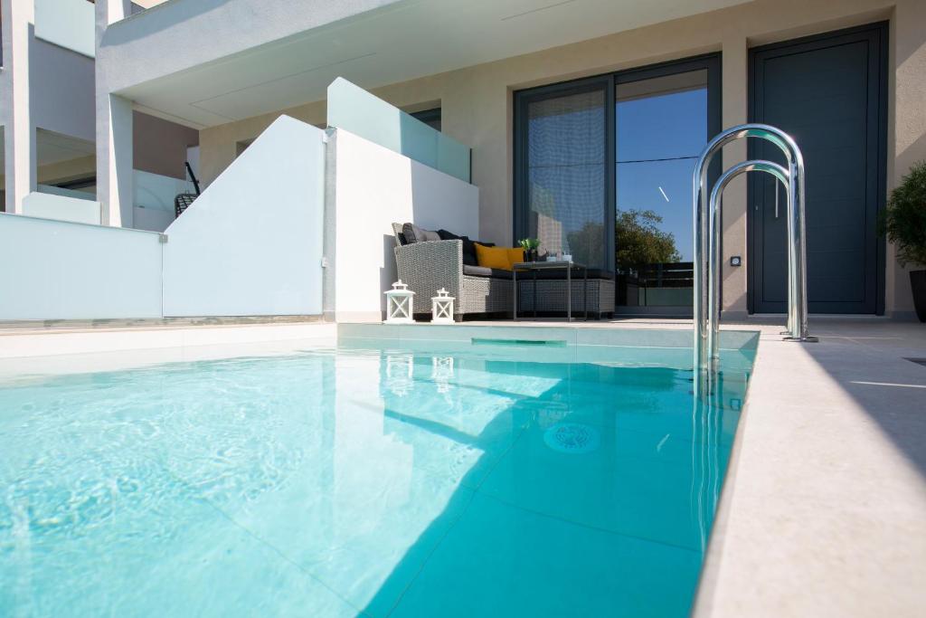 a swimming pool with blue water in a house at Elysian Luxury Suite in Preveza