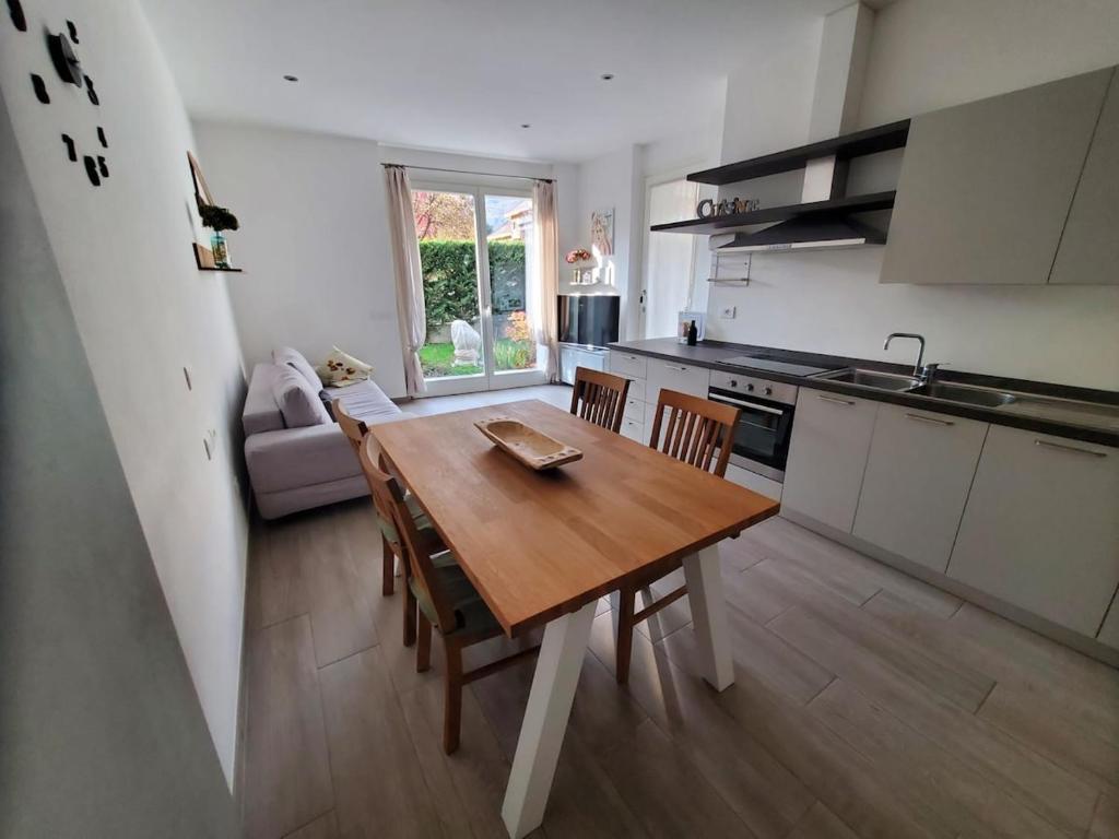 a kitchen with a wooden table and chairs in a room at Appartamento La Camelia in Sondrio