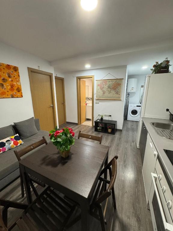 a kitchen and a living room with a table and chairs at Rooms Capulino in Málaga