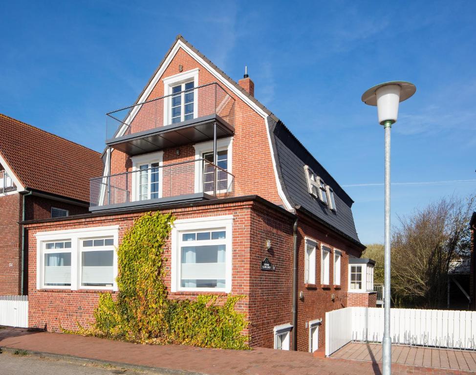 a brick house with a balcony on top of it at Haus Nordland in Juist