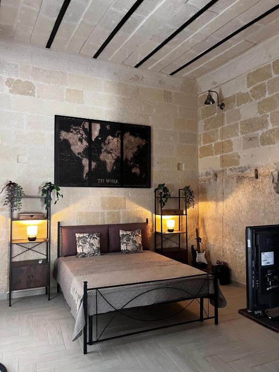 a bedroom with a bed with two lights on the wall at ITALY Home 16 in Grottaglie