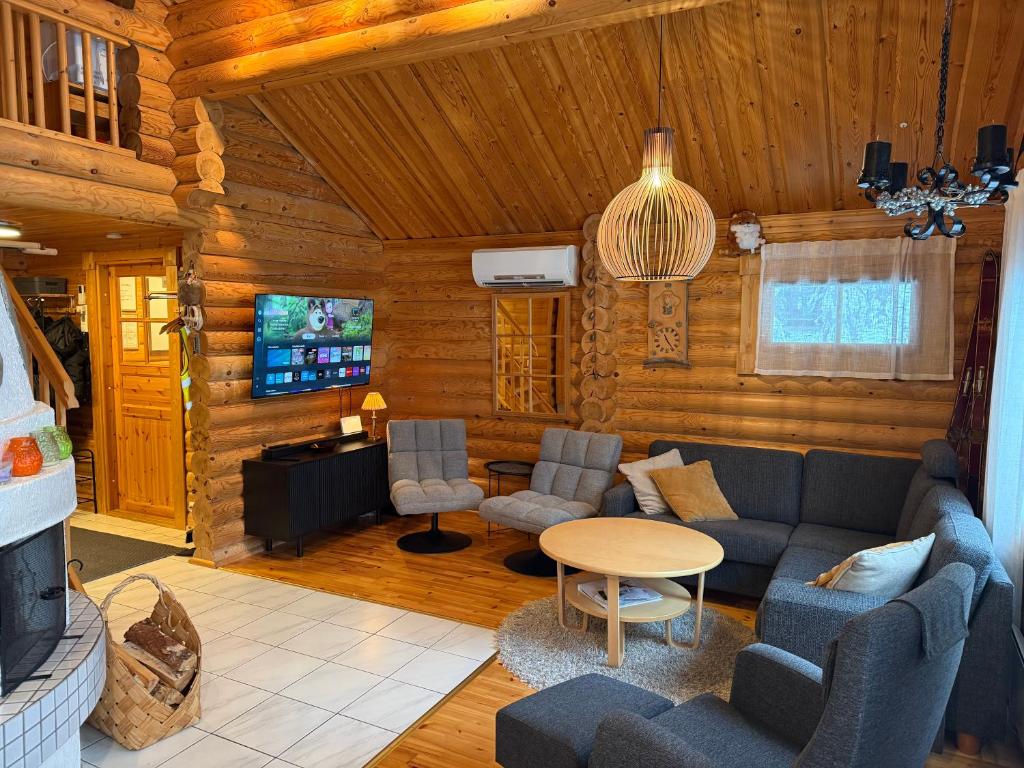 a living room with a couch and chairs and a tv at Villa Rukan Honka in Ruka