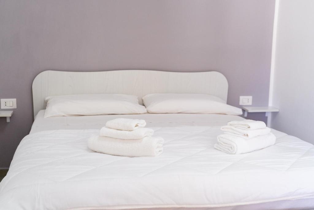 a white bed with towels on top of it at Mulino Suites in Scalea
