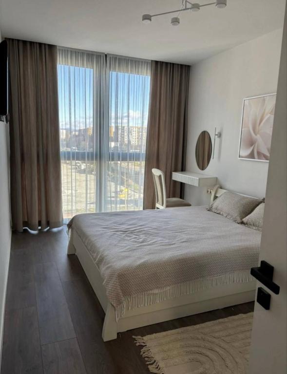 a bedroom with a large bed and a large window at Parkr Land Elite in Uzhhorod
