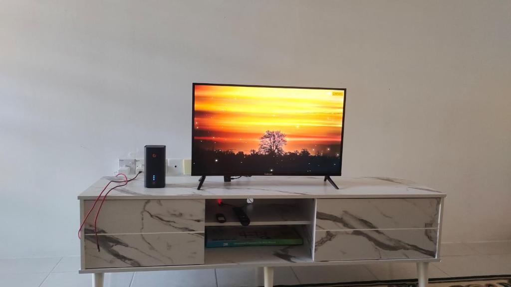 a flat screen tv sitting on top of a cabinet at HAIZRINA HOMESTAy in Sungai Petani