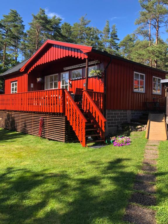 a red house with a red roof and a yard at Flott hytte - Enhus, Kråkerøy in Fredrikstad