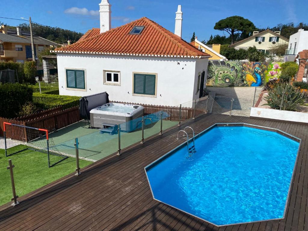 a villa with a swimming pool in front of a house at Belas Rustic Chick in Belas