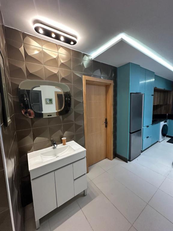 a kitchen with a sink and a tv on the wall at Apprt Saidia berqia in Saïdia