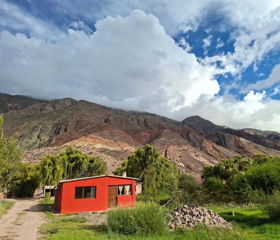 a small red house in front of a mountain at Cabaña Terracota in Maimará