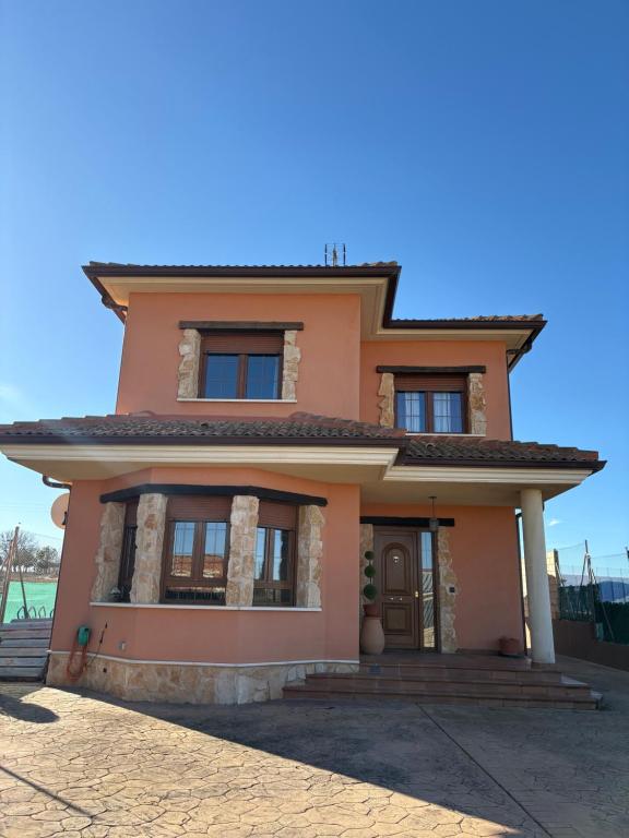 a pink house with a blue sky in the background at VUT Casa Rural El Besito in Campillo de Aranda