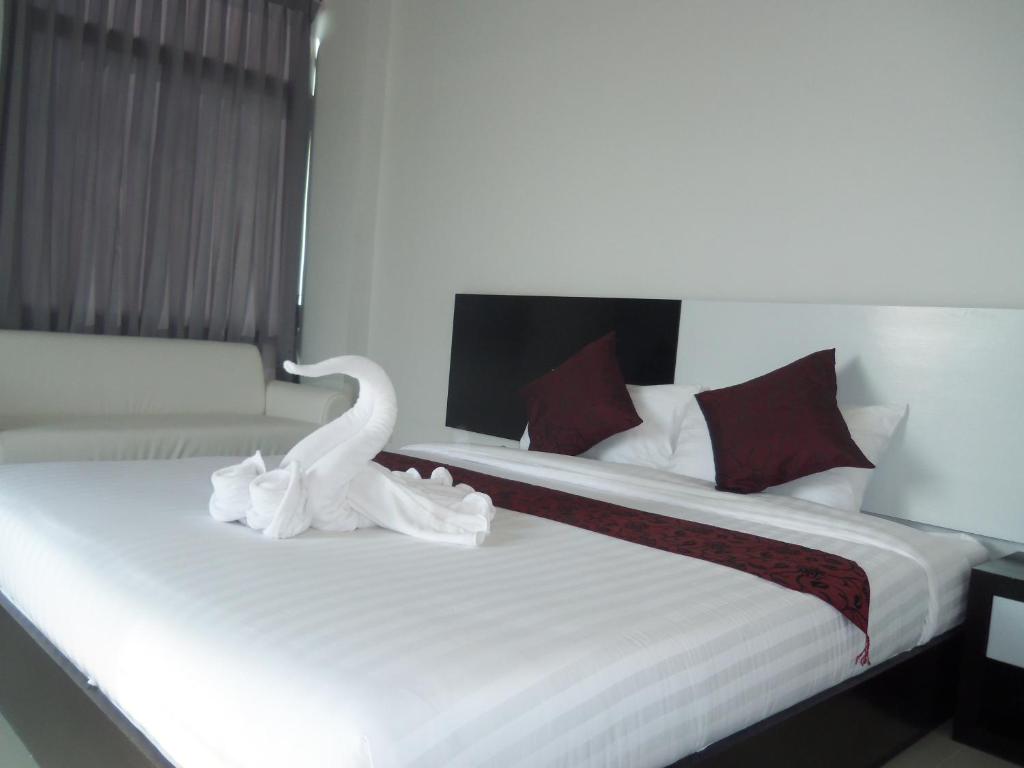 Una habitación de hotel con dos camas con un cisne. en Home Rezidence Prachinburi en Si Maha Phot