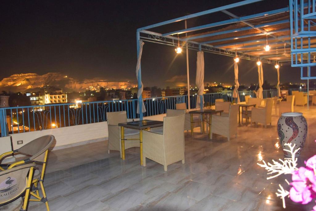 a rooftop patio with tables and chairs at night at Flamingo Boutique hotels in Luxor