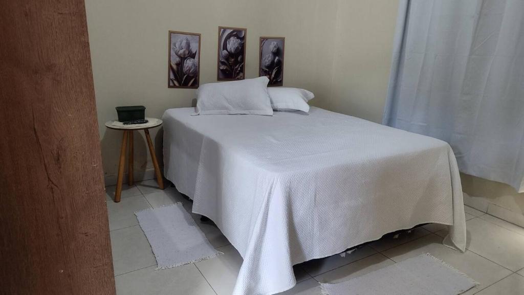 a bedroom with a bed with a white blanket on it at Lolt Vila Boa Goiás in Goiás