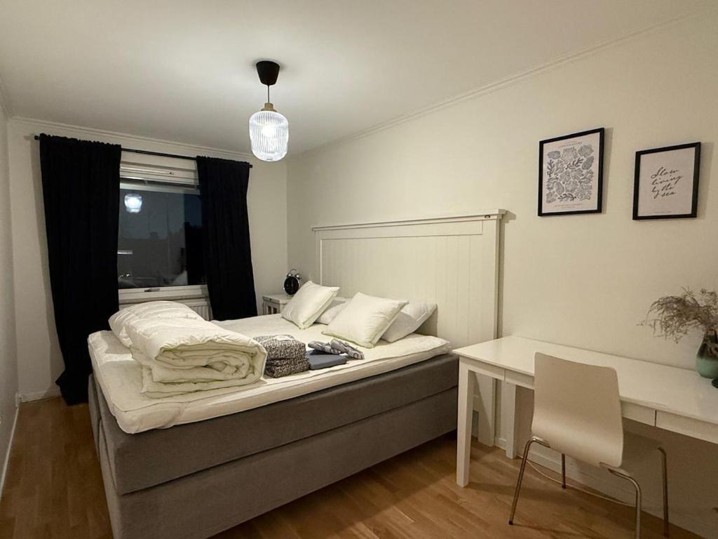 a bedroom with a bed and a desk and a table at Siam Homestay in Mölndal