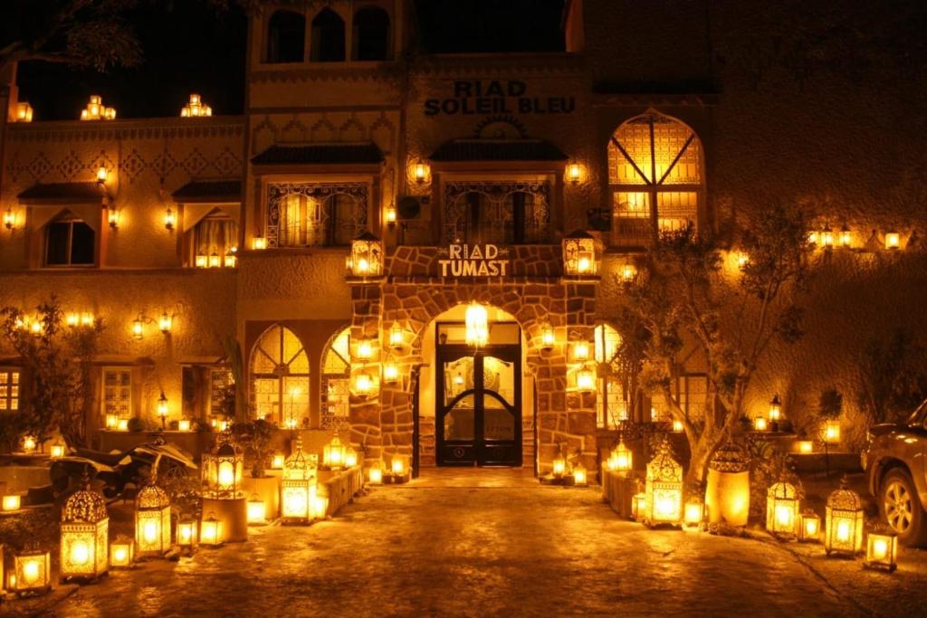 a building with lights in front of it at night at Hotel Soleil Blue in Boumalne Dades