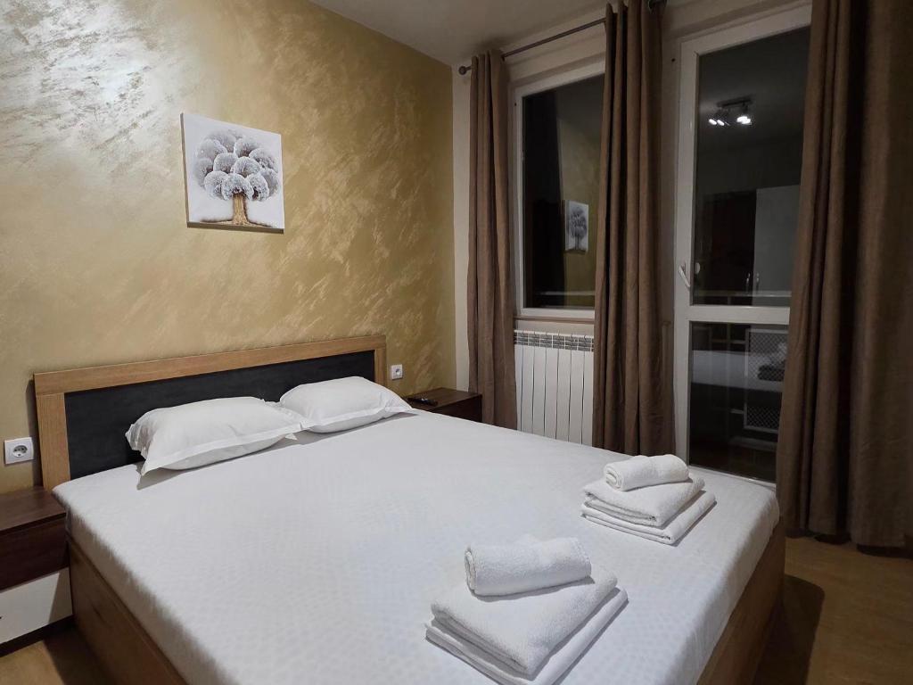a bedroom with a white bed with towels on it at Дунав билдингс 3 in Pleven