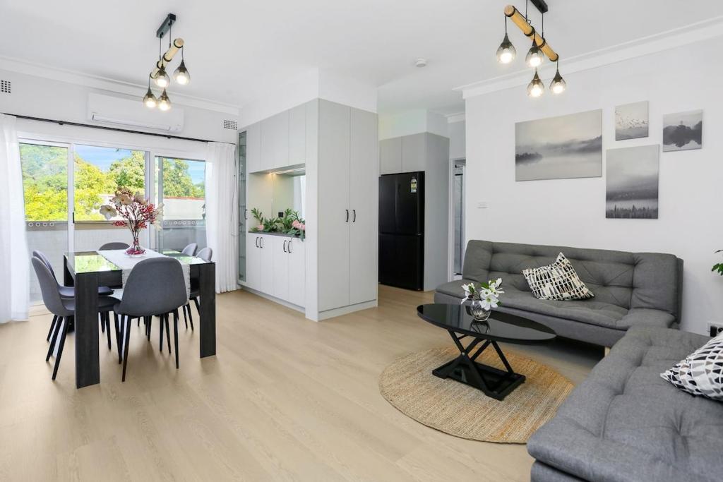 a living room with a table and a dining room at The Modern Retreat in Sydney