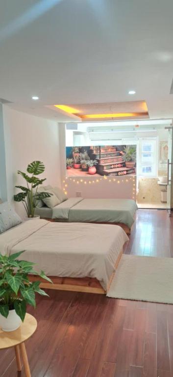 a bedroom with two beds and a potted plant at Khu Hòa Bình in Da Lat