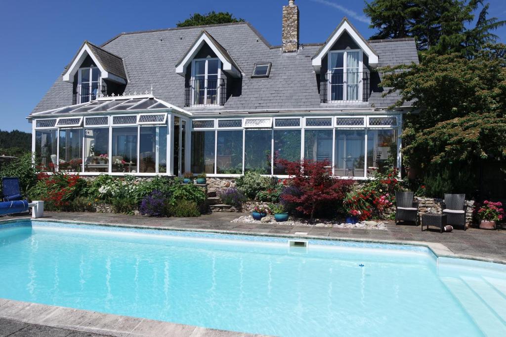 a house with a swimming pool in front of a house at Watchcombe House in Colyton